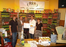 Check handover at the action day at the REWE market in Koll in Bechen in the summer of 2009 in front of a shelf with GEPA products