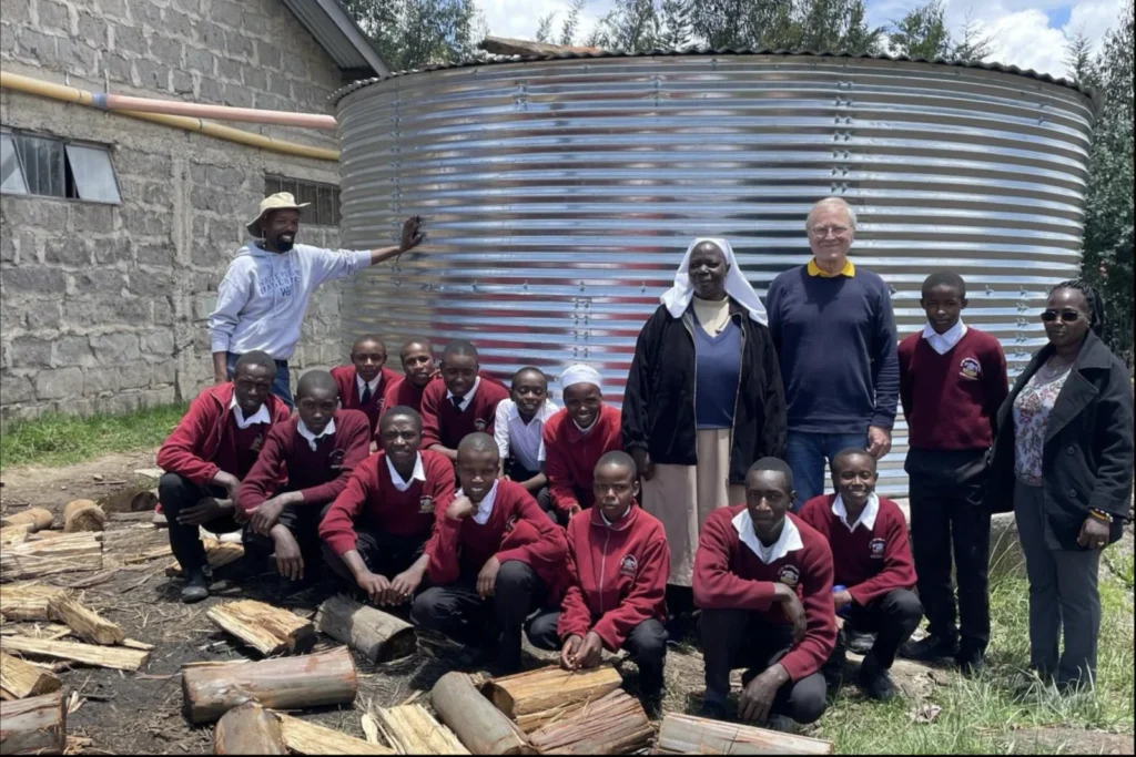 Students, pupils and teachers in front of the rainwater tank funded by the foundation